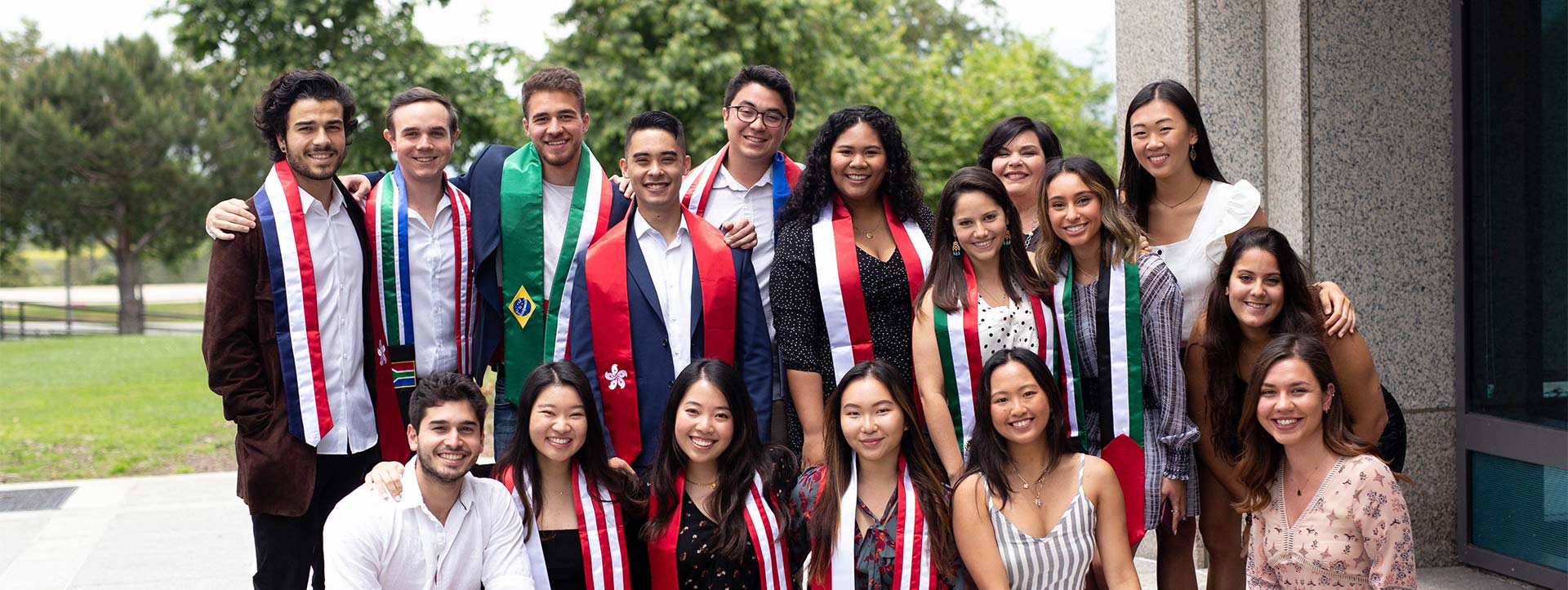 Group of international students wearing sashes representing their countries of orgin